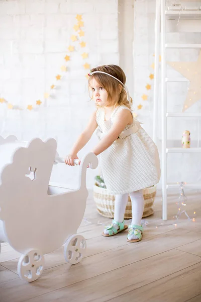 Beyaz Elbiseli Küçük Şirin Kız Oyuncak Çelenklerle Süslenmiş Parlak Bir — Stok fotoğraf