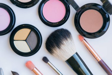 Makyaj ve makyaj fırçaları masaya. Göz farı, ruj, parlatıcı, rimel. Makyaj malzemeleri ve aletleri. Güzellik ve Moda