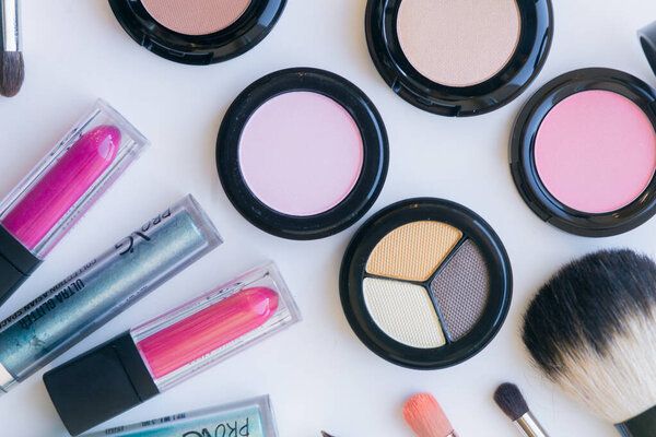 Makeup and makeup brushes on the table. Eye shadow, lipstick, gloss, mascara. Materials and tools for makeup. Beauty and Fashion