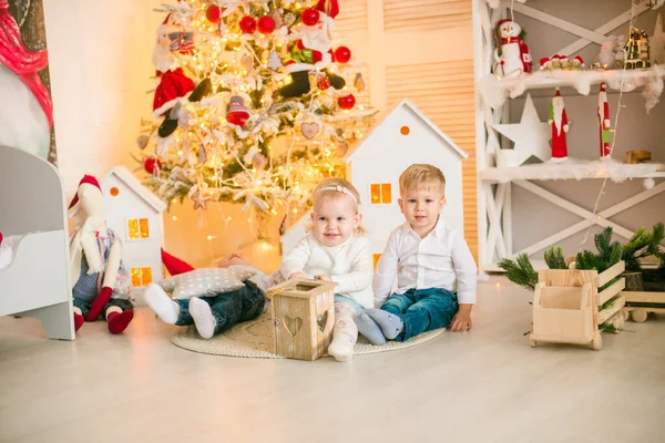 Sarışın Şirin Çocuklar Noel Ağacının Yanında Süslenmiş Parlak Bir Odada — Stok fotoğraf