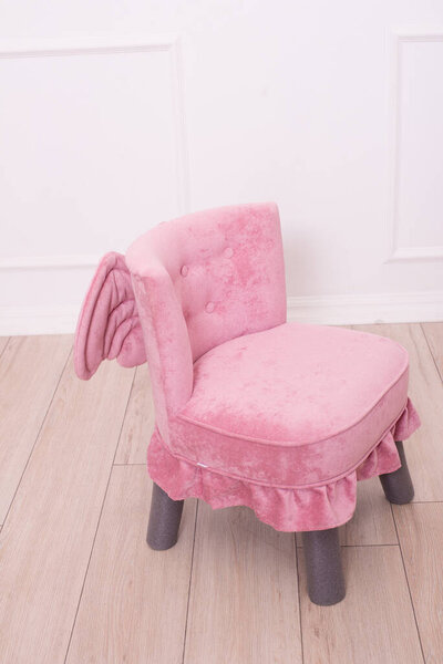 Cute pink soft chair with wings for the little princess's nursery. Children's furniture. Furniture for little girls