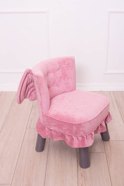 Cute pink soft chair with wings for the little princess's nursery. Children's furniture. Furniture for little girls