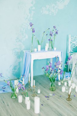 Yatak odasının içi havadar yatak odası ve bahar mavisi süsen çiçekleri ve mumlarla süslenmiş mavi duvar. Gelinin Yatak Odası