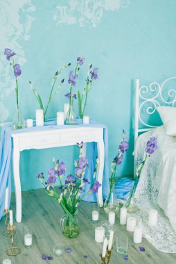 Yatak odasının içi havadar yatak odası ve bahar mavisi süsen çiçekleri ve mumlarla süslenmiş mavi duvar. Gelinin Yatak Odası