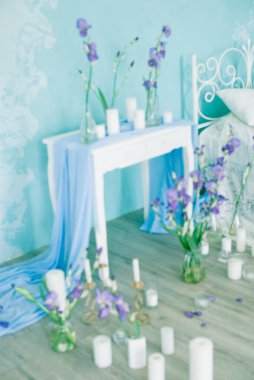 Yatak odasının içi havadar yatak odası ve bahar mavisi süsen çiçekleri ve mumlarla süslenmiş mavi duvar. Gelinin Yatak Odası