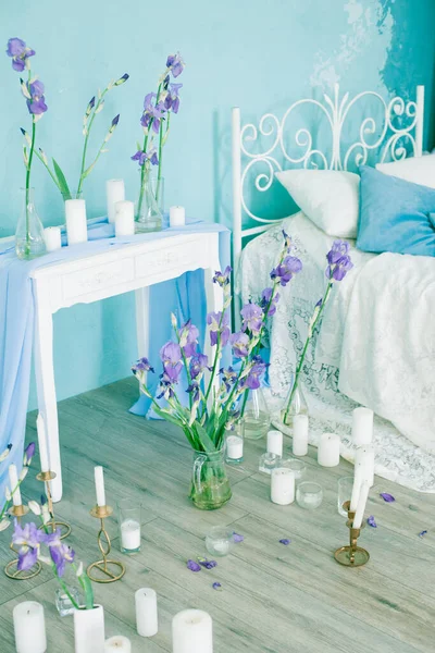 Wnętrze Sypialni Przestronnym Łóżkiem Niebieską Ścianą Ozdobione Wiosenno Niebieskimi Irysami — Zdjęcie stockowe