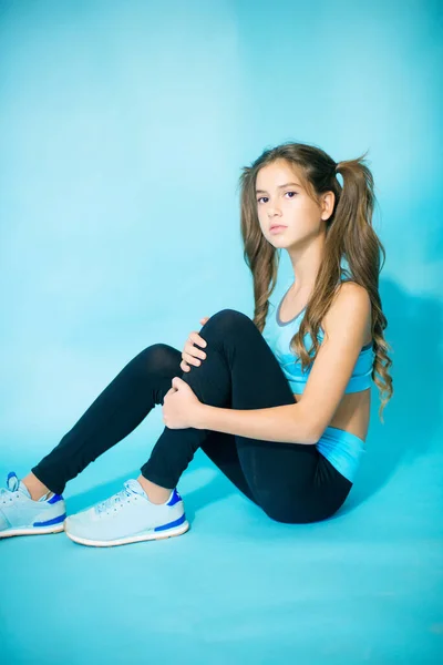 Schattig Tienermeisje Met Lang Blond Haar Fitnesskleding Een Blauwe Achtergrond — Stockfoto