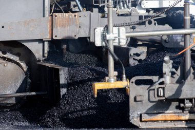 İnşaat alanının üzerine yeni asfalt seriyorlar.