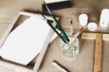 Sanatçının çalışma yeri: fırçalar, boyalar, resim çerçevesi, palet