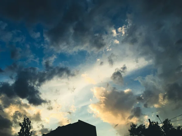 Голубое Небо Осколках Серо Белых Облаков Сквозь Которые Прорываются Солнечные — стоковое фото