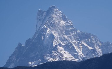 Mavi gökyüzü ve bulutların arka planında kar ve ormanla kaplı dağlarla muhteşem bir sonbahar manzarası. Everest Dağı, Nepal.