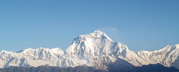 Berglandschap panorama. Majestueuze bergtoppen bedekt met sneeuw tegen een helderblauwe hemel. — Stockfoto