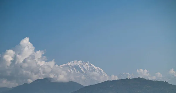 Górska panorama krajobrazu. Majestatyczne szczyty gór pokryte śniegiem na tle jasnego niebieskiego nieba. — Zdjęcie stockowe