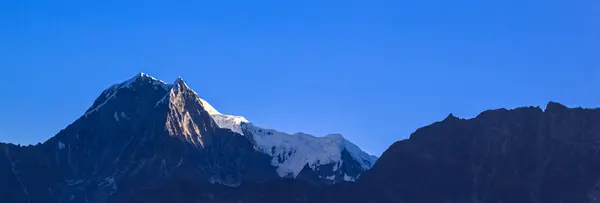 Montaña cubierta de nieve con cielo azul, nube y niebla — Foto de Stock