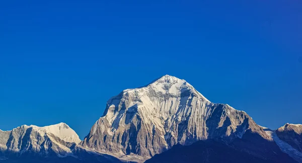 Met sneeuw bedekte berg met blauwe lucht, wolken en mist — Stockfoto