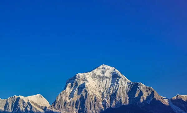 Montagna innevata con cielo blu, nuvola e nebbia — Foto Stock