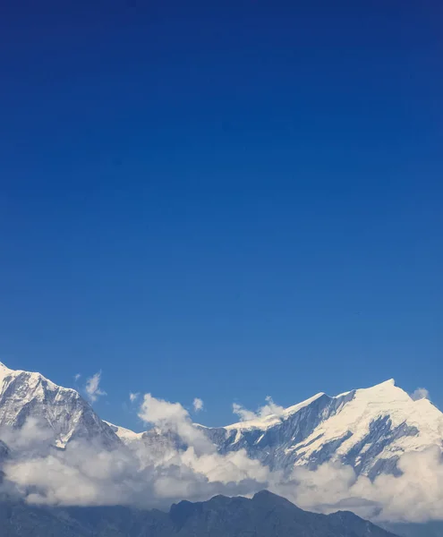 Χιονισμένο βουνό με μπλε ουρανό, σύννεφο και ομίχλη — Φωτογραφία Αρχείου
