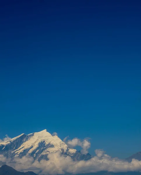 Заснеженная гора с голубым небом, облаком и туманом — стоковое фото