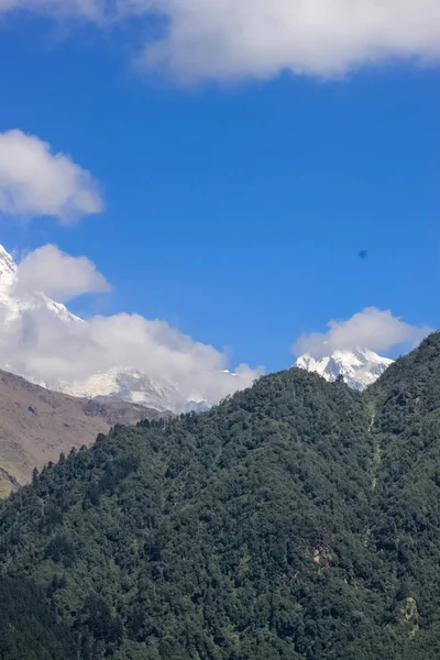 Montanha coberta de neve com céu azul, nuvem e nevoeiro — Fotografia de Stock