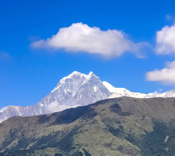 Montanha coberta de neve com céu azul, nuvem e nevoeiro — Fotografia de Stock