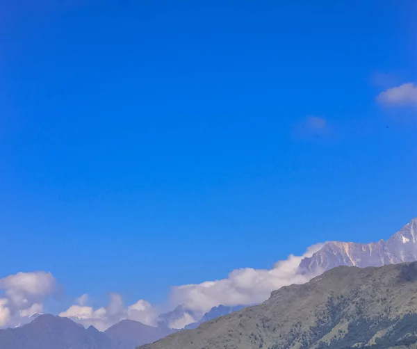 Montaña cubierta de nieve con cielo azul, nube y niebla — Foto de Stock