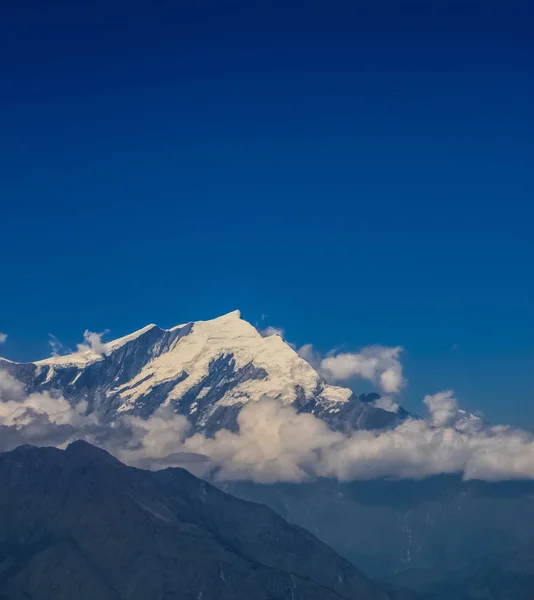 Montaña cubierta de nieve con cielo azul, nube y niebla — Foto de Stock