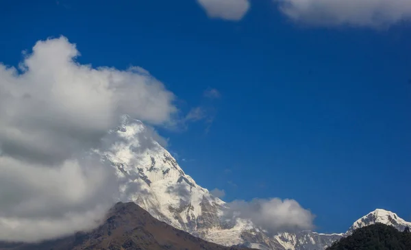 Montanha coberta de neve com céu azul, nuvem e nevoeiro — Fotografia de Stock