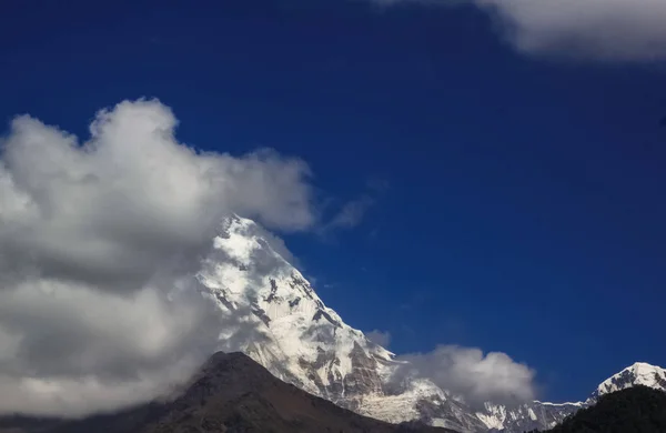 Met sneeuw bedekte berg met blauwe lucht, wolken en mist — Stockfoto