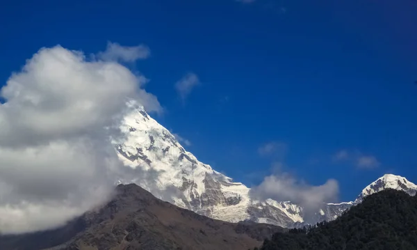 Met sneeuw bedekte berg met blauwe lucht, wolken en mist — Stockfoto