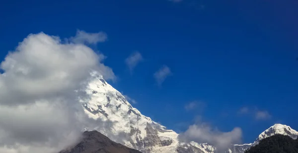 Montagna innevata con cielo blu, nuvola e nebbia — Foto Stock