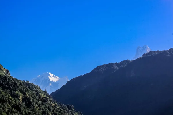 Заснеженная гора с голубым небом, облаком и туманом — стоковое фото