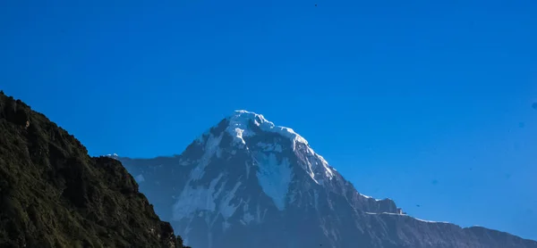 Montanha coberta de neve com céu azul, nuvem e nevoeiro — Fotografia de Stock