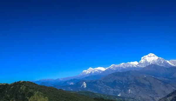 Bela e incrível montanha coberta de neve com céu azul — Fotografia de Stock