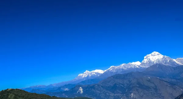 Hermosa y asombrosa montaña cubierta de nieve con cielo azul — Foto de Stock