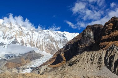 Tepenin tepesinde, kar ve beyaz bulutlarla kaplı.