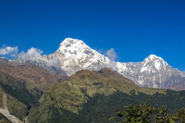 Tepenin tepesinde, kar ve beyaz bulutlarla kaplı.