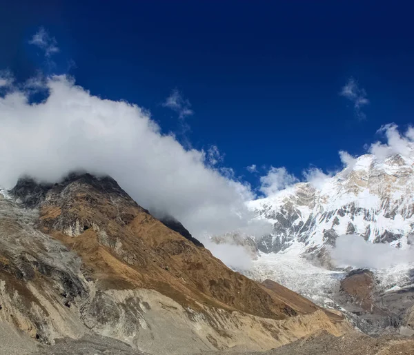 Parte superior de la colina, cubierta de nieve y nubes blancas —  Fotos de Stock