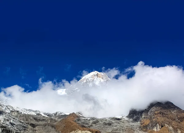 In cima alla collina, coperta di neve e nuvole bianche — Foto Stock