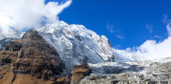 Parte superior de la colina, cubierta de nieve y nubes blancas —  Fotos de Stock