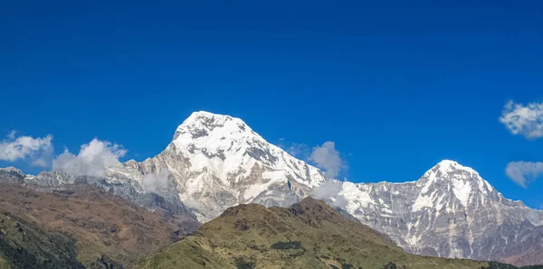 Вершина холма, покрытая снегом и белыми облаками — стоковое фото