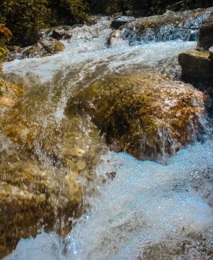 Su, dağdaki şelale gibi akıyor.