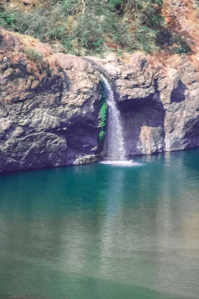 Water running over brown rocks like small waterfall