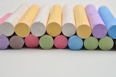 W üzerinde çizgiler halinde düzenlenmiş çeşitli renklerde tebeşir parçaları