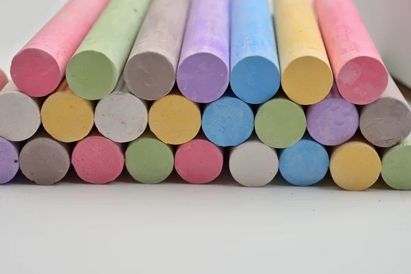Pedaços de giz em uma variedade de cores dispostas em linhas em um w — Fotografia de Stock