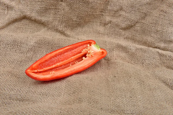 La mitad de la pimienta roja acostado en el fondo del saco. Concepto de — Foto de Stock