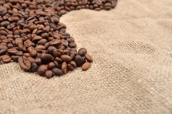 Foto vintage, granos de café tostados sobre fondo de yute marrón. Mo. —  Fotos de Stock