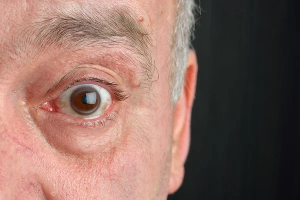 Close up picture of brown mature human eye, on the eye you can s — Stockfoto