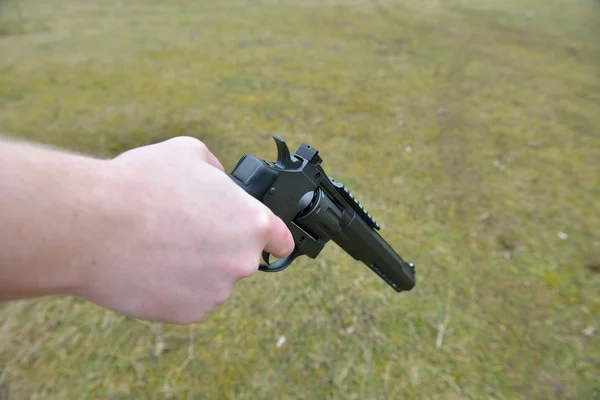 Πυροβόλα όπλα και θέμα ασφάλειας: άνδρας με ένα όπλο έτοιμη να πυροβολήσει το χέρι — Φωτογραφία Αρχείου