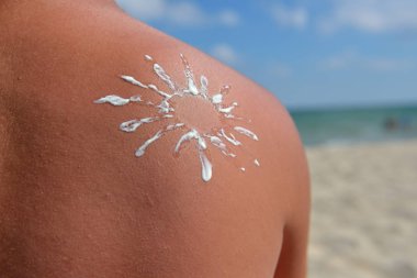 Yakın güneş genç bir adamın omzunda güneş kremi ile çizilmiş 