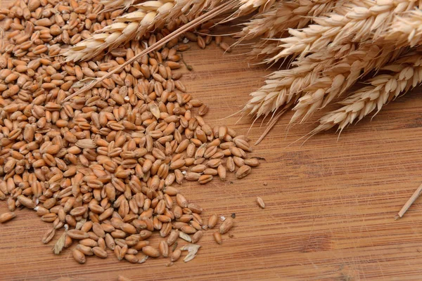 Пшеничні вуха і зерна на дерев'яному столі. Зернові, сільський фон — стокове фото